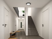 Moderner Flur mit schwarzer Deckenleuchte, weißen Türen und grauem Betonboden, minimalistisch eingerichtet