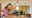 Femme tenant une ampoule LED blanche suspendue dans une cuisine moderne avec meubles en bois.
