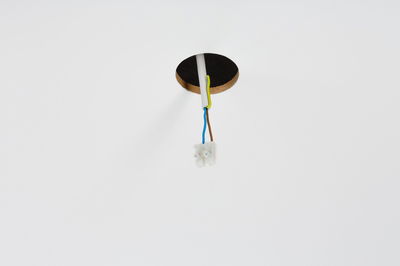 Electrical connection cables with plastic terminal block in white ceiling opening for lighting setup.