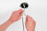 Hands connecting electrical wires with screw terminal on white ceiling for lighting installation
