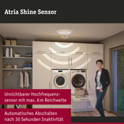 Weiße Deckenleuchte mit unsichtbarem Hochfrequenzsensor in moderner Waschküche mit Waschmaschine