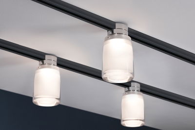 Plafonnier moderne avec trois lampes en verre blanc sur rail noir pour un éclairage élégant