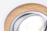 Close-up of round LED recessed spotlight with natural wood frame and aluminum ring