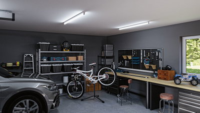 Moderne Garage mit grauem Auto, weißem Fahrrad auf Ständer und Werkbank mit Werkzeugwand und LED-Deckenleuchten