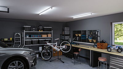 Modern garage with grey car, white bike on stand, workbench with tool board and LED ceiling lights