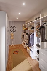 Moderner begehbarer Kleiderschrank mit weißen Regalen, Holzboden und warmem LED-Deckenlicht