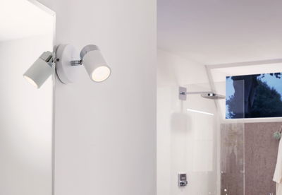 Applique murale LED blanche moderne avec accents chromés, idéale pour l’éclairage de salle de bain.