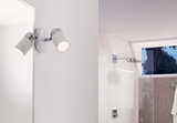 Modern white LED wall spotlight with chrome accents, perfect for bathroom lighting.