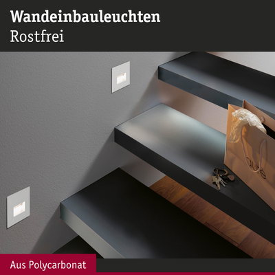 Eingebaute Wandleuchten aus rostfreiem Polycarbonat beleuchten moderne schwarze Treppenstufen elegant.