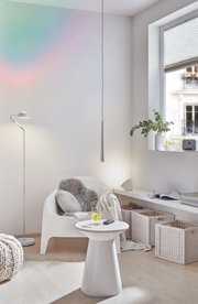 Moderner Wohnbereich mit weißem Kunststoffstuhl, Beistelltisch und natürlicher Beleuchtung für gemütliche Einrichtung