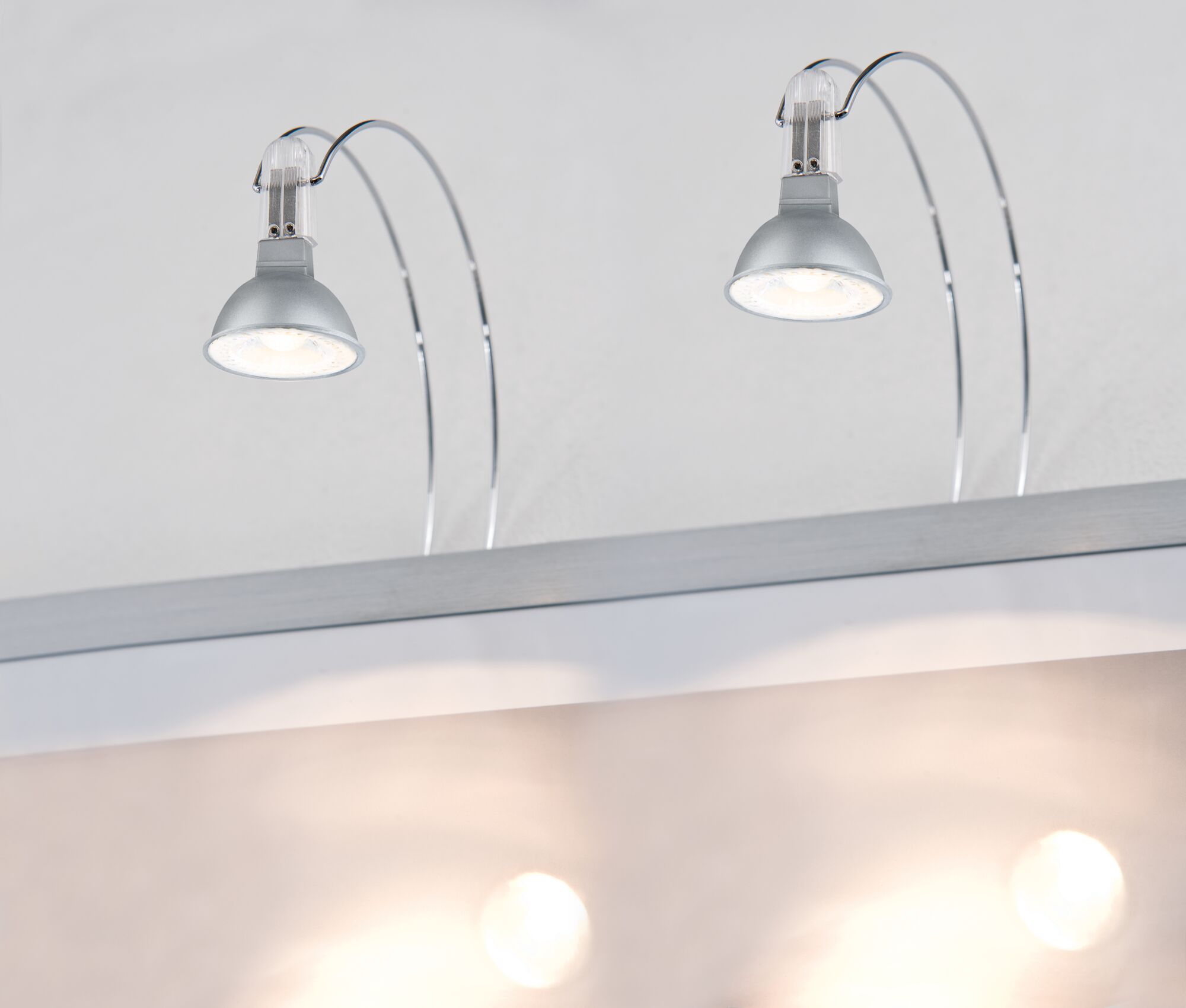 Two silver LED spotlights with curved chrome arms for wall mounting, modern lighting solution