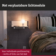 Witte wandlamp met verplaatsbare lichtmodule naast bed met grijze muur en gebreide deken
