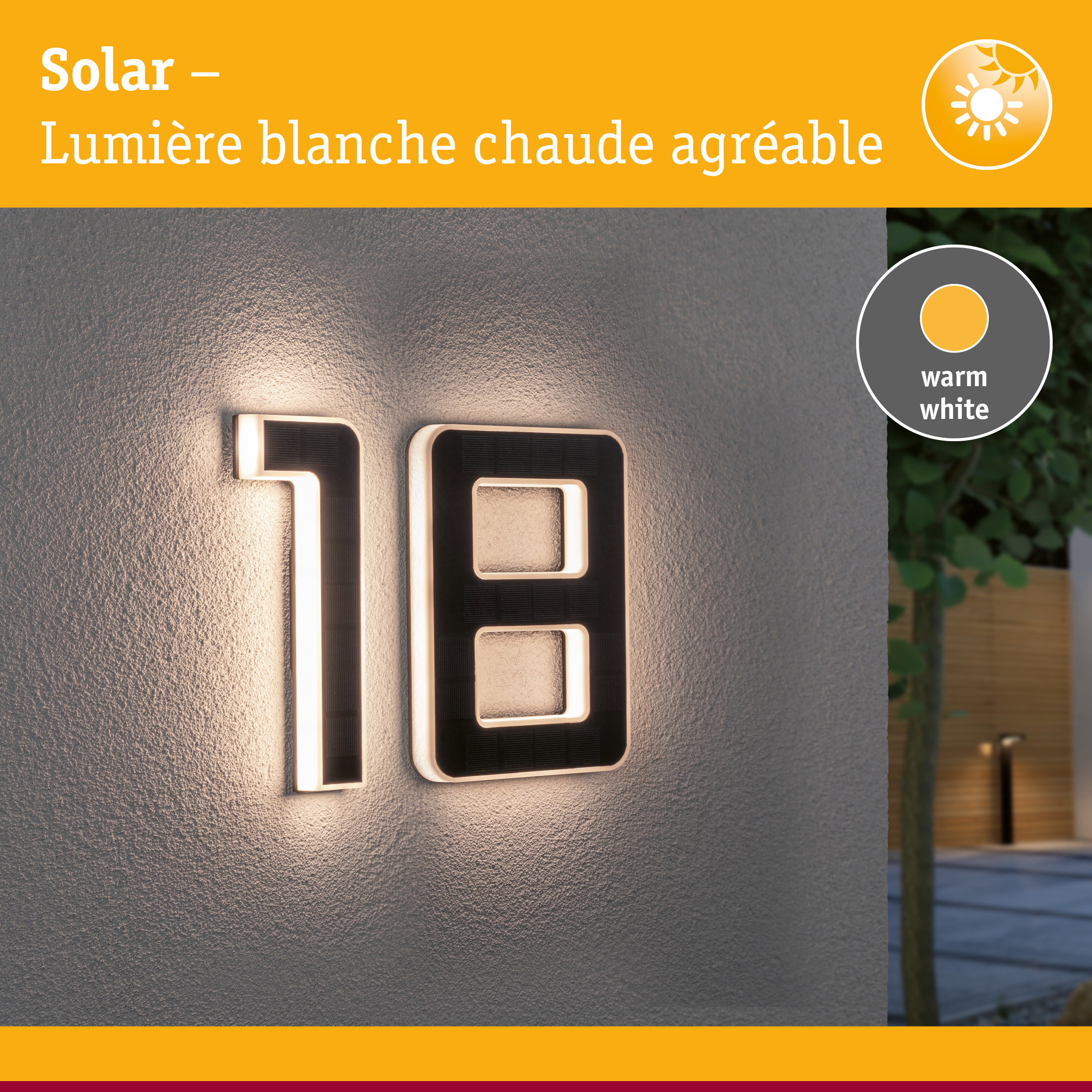 Numéro de maison solaire en matériau noir avec lumière LED blanc chaud sur mur gris