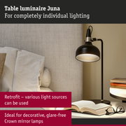 Black metal Juna table lamp with adjustable light beside sofa and books for reading