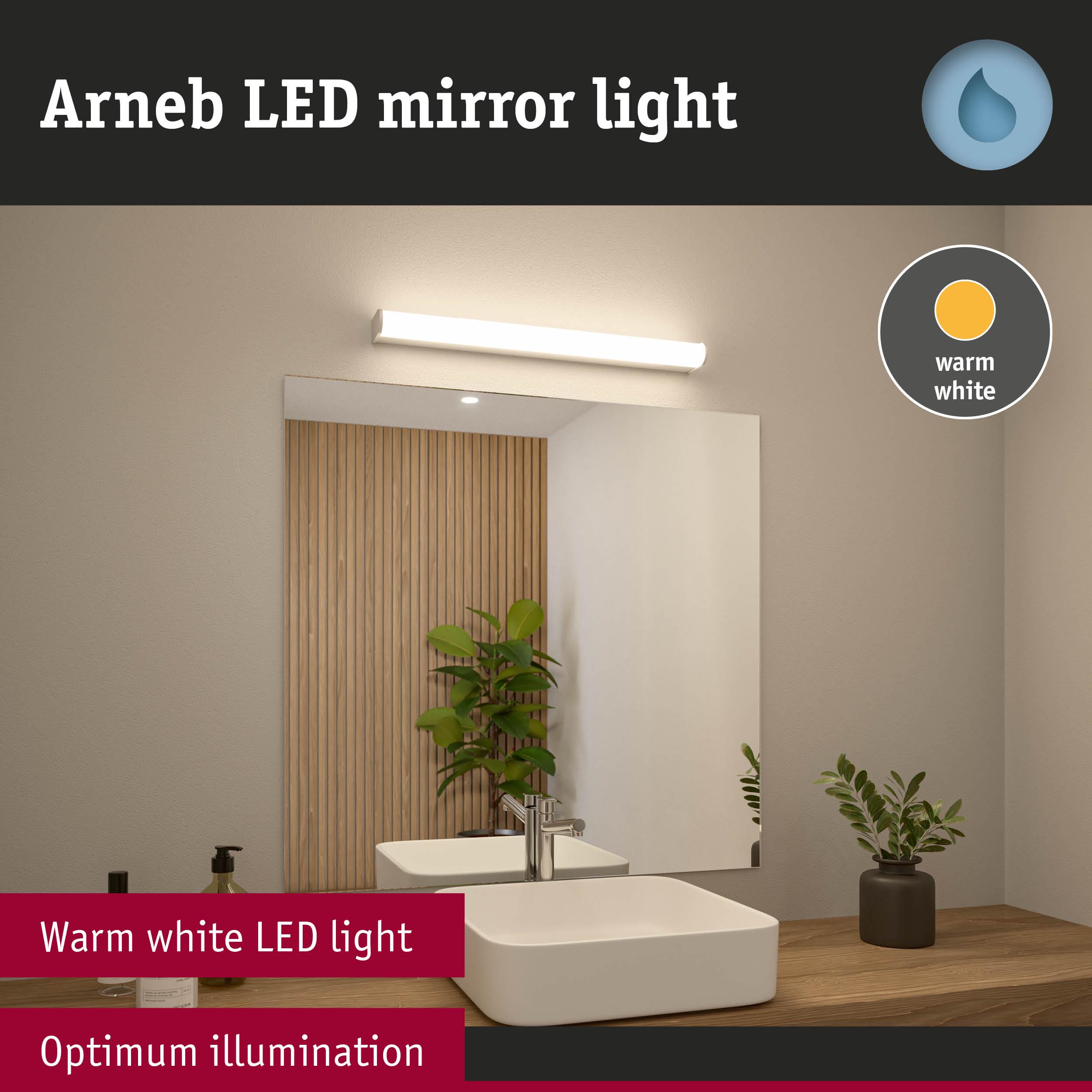 Arneb LED mirror light with warm white illumination above white sink on wooden bathroom shelf
