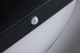 Close-up of white motion sensor on black plastic frame with modern LED lighting panel