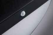 Gros plan d'un détecteur de mouvement blanc en plastique sur boîtier noir pour éclairage LED