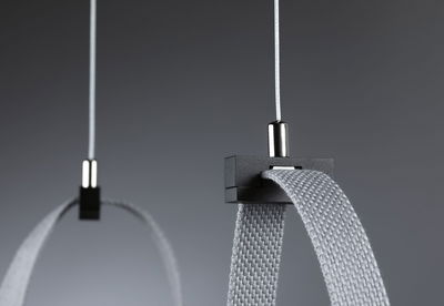 Close-up of grey textile strap with black plastic holder and white cable for lighting system.