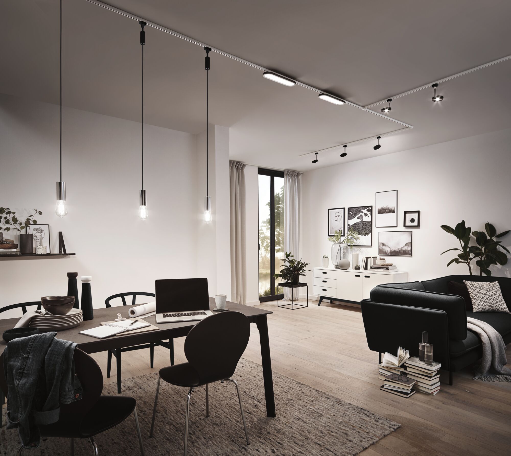 Modern living room with black pendant lights and LED track lighting in bright wooden space.