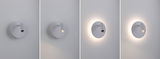 Four views of a white metal LED wall light with adjustable spotlight and ambient backlight