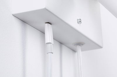 Nærbillede af hvid kabeltilslutning på hvid metalbeslag til LED-belysning