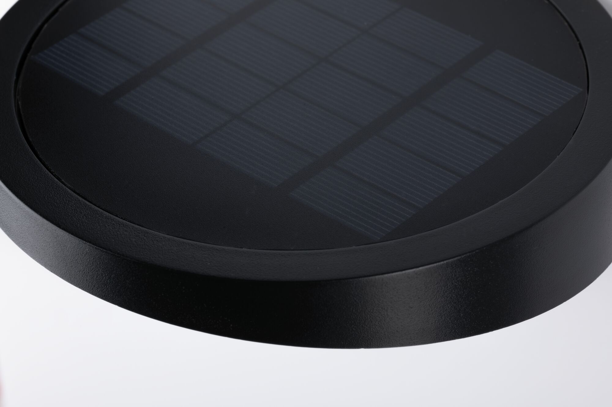 Sort rundt solpanel med tekstureret overflade i robust materiale til bæredygtig energi.