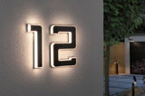 Illuminated house number 12 with black frame and warm white LED light on exterior wall lighting entrance