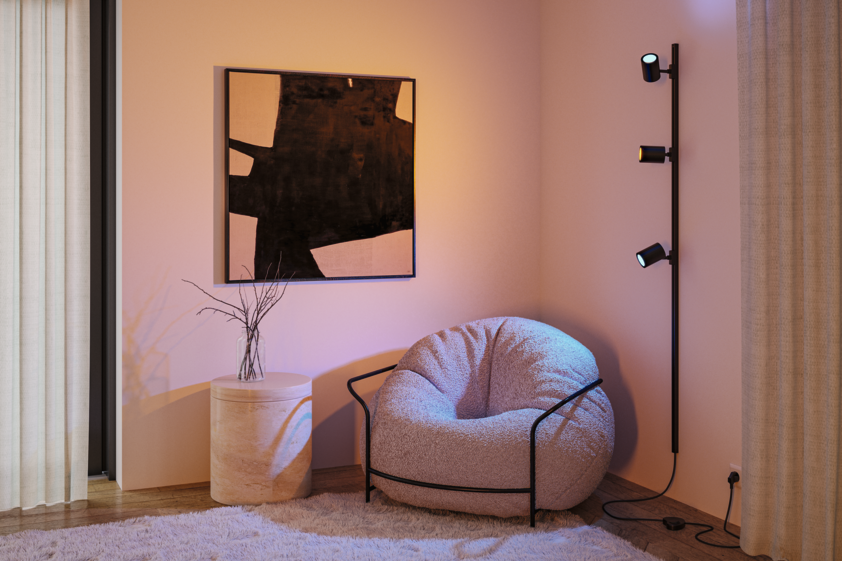 Schwarze Wandlampe mit drei verstellbaren Spots in modernem Wohnzimmer mit gemütlichem Sessel und Teppich.