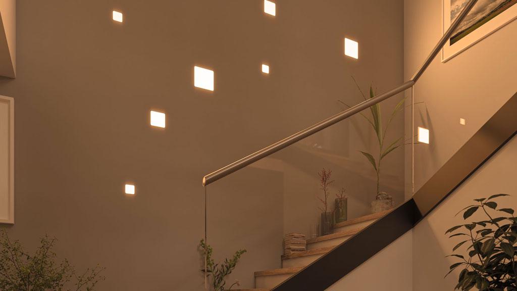 Modern staircase with glass railing and warm white square wall lights for hallway lighting