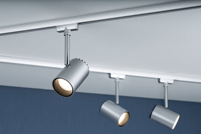 Three silver metal LED spotlights mounted on white ceiling track for accent lighting in rooms