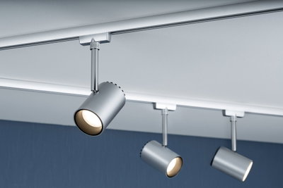 Drei silberne LED-Strahler aus Metall an weißer Schiene an der Decke montiert für Akzentbeleuchtung