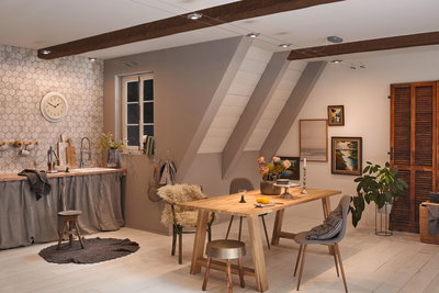 Modernes Esszimmer mit Holztisch, Stühlen und warmweißer LED-Seilbeleuchtung an Holzbalken.