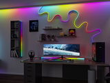 Installation gaming moderne avec écran ultra-large et bandes LED colorées en éclairage RGB flexible.