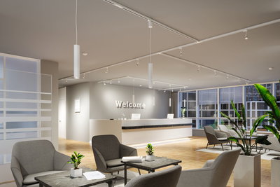 Modern reception area with white pendant lights and grey armchairs on parquet floor with plants.