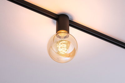 Schwarze Deckenleuchte mit runder Glühbirne und warmweißem LED-Licht für moderne Innenräume
