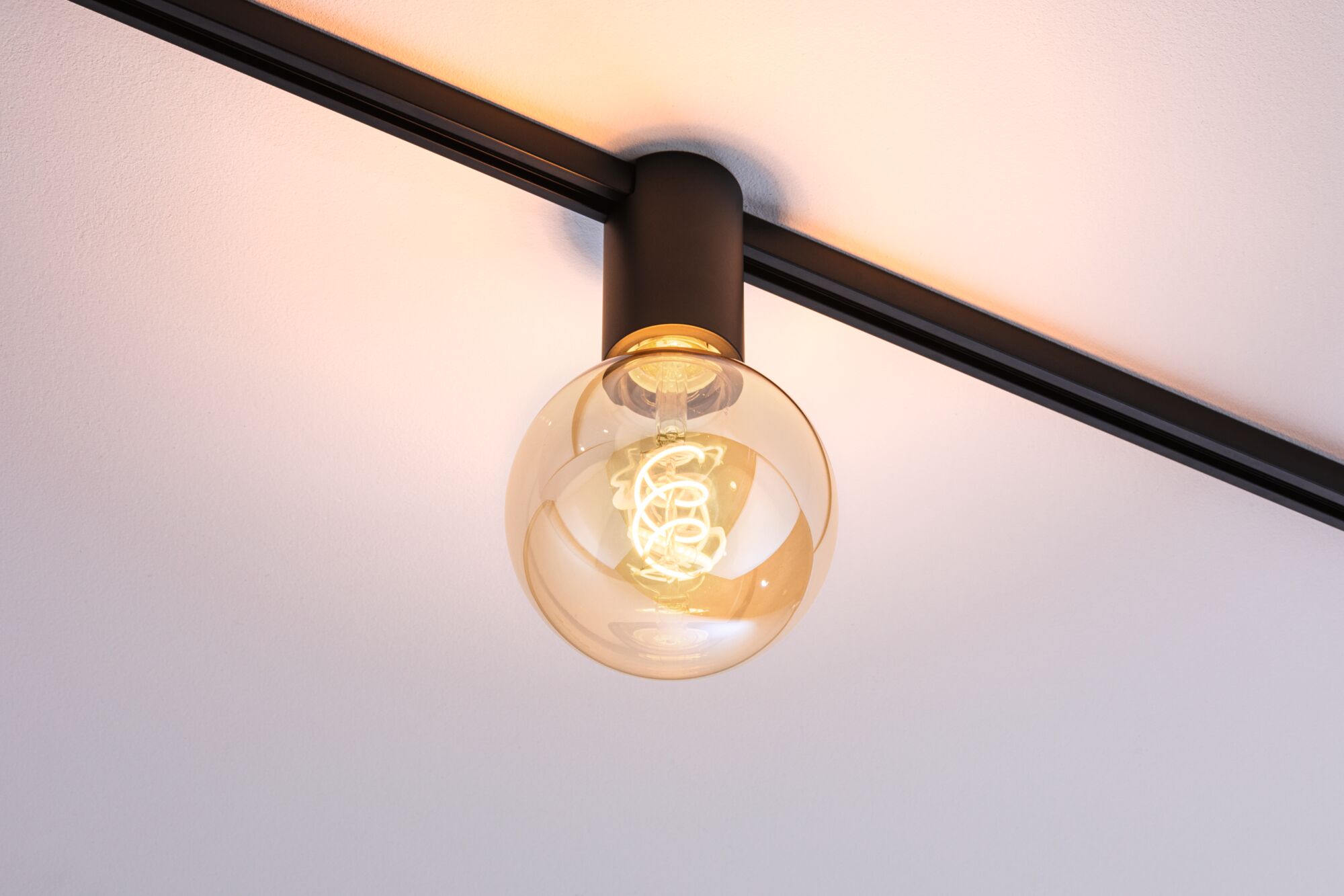Schwarze Deckenleuchte mit runder Glühbirne und warmweißem LED-Licht für moderne Innenräume