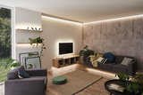 Salon moderne avec éclairage LED indirect au plafond, murs et meubles pour une ambiance chaleureuse