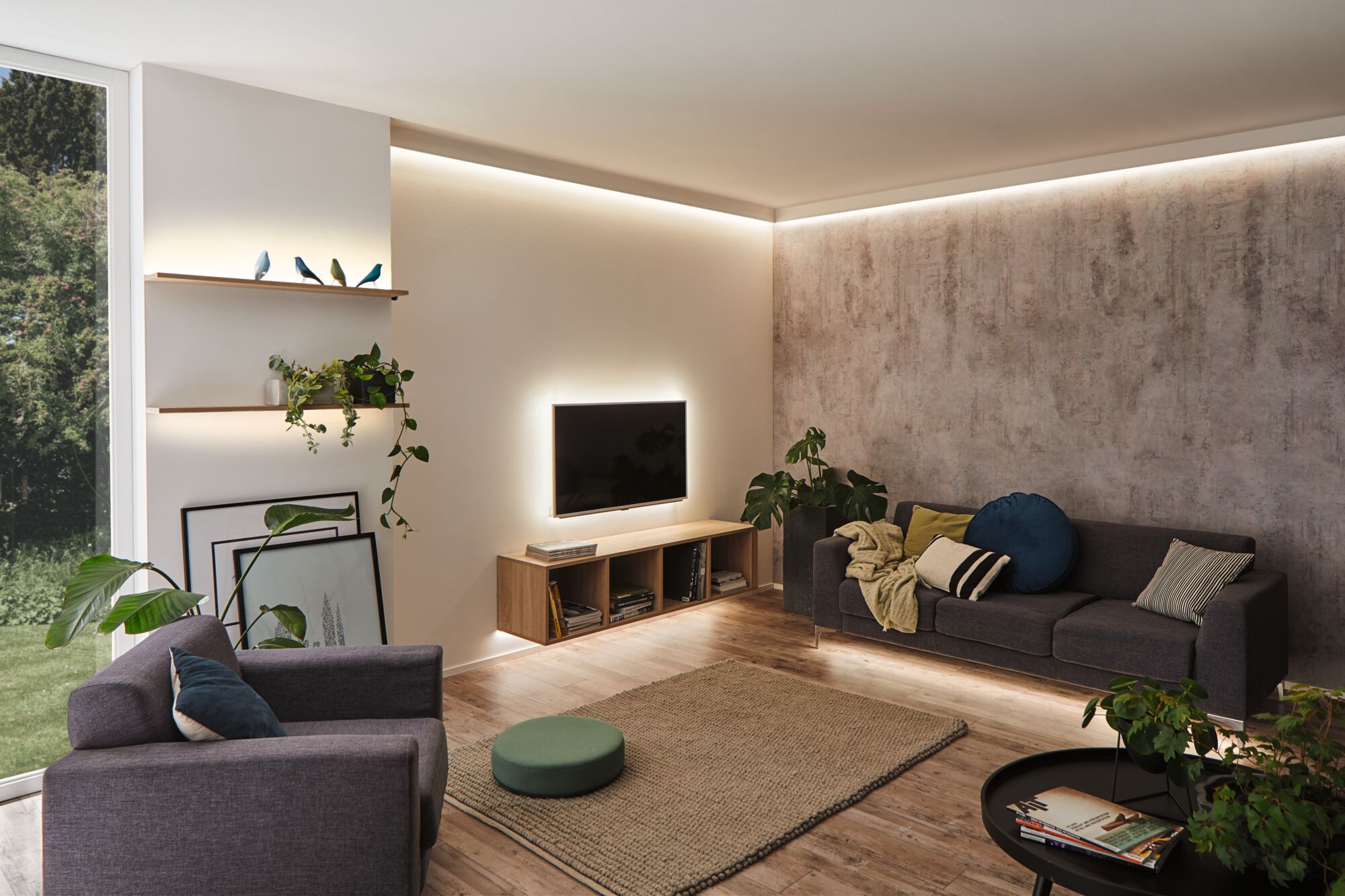 Modernes Wohnzimmer mit indirekter LED-Beleuchtung an Decke, Wand und Möbeln für gemütliche Atmosphäre
