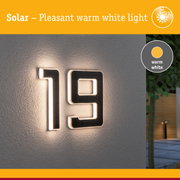 Solar illuminated house number 19 with warm white light on grey wall for outdoor lighting