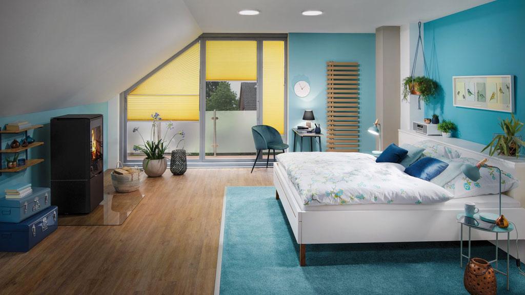 Modernes Schlafzimmer mit blauen Wänden, weißem Bett, Holzfußboden und gelben Plissees, gemütliche Beleuchtung.
