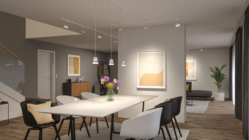 Salle à manger moderne avec table blanche, chaises noires et blanches, et suspensions blanches minimalistes.