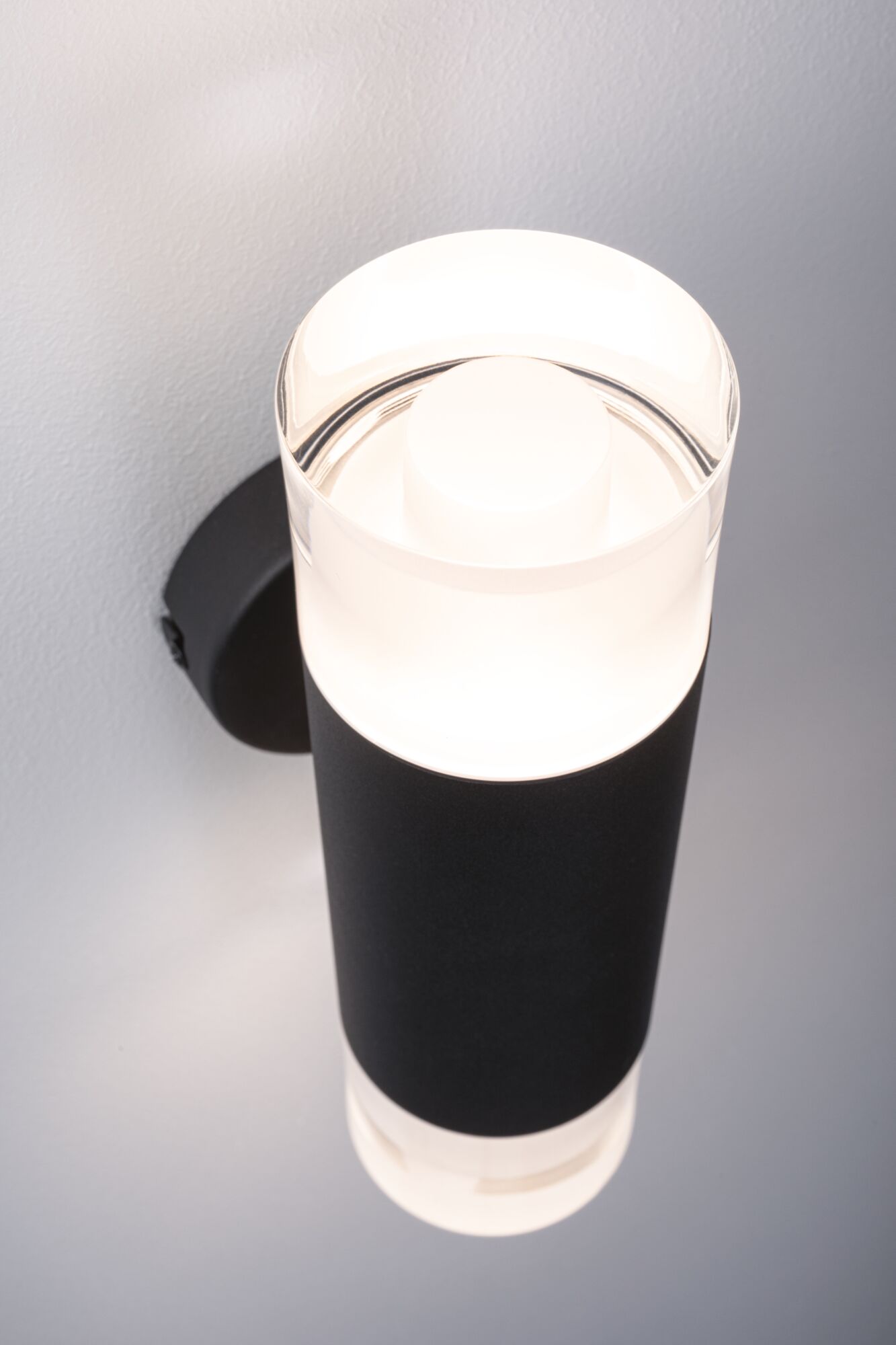 Moderne sort metal væglampe med cylindrisk glas og varmt hvidt LED-lys til indendørs brug