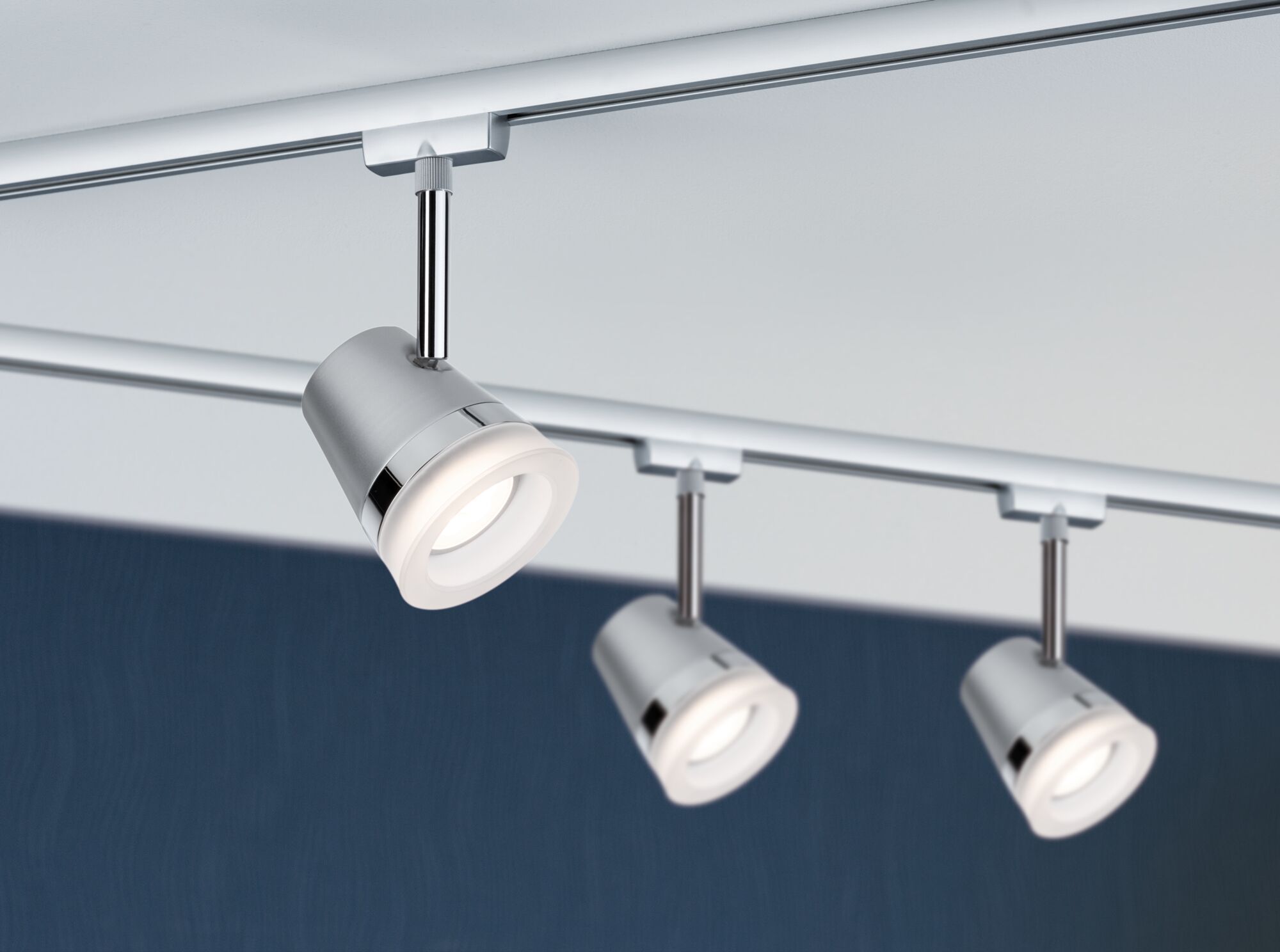 Drei silberne LED-Strahler aus Metall an Schienensystem für moderne Raumbeleuchtung