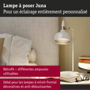 Lampe à poser Juna blanche en métal avec lumière chaude près d'un canapé et des livres