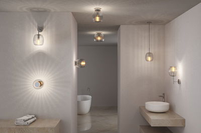 Modern transparent glass wall and ceiling lights with warm illumination in a minimalist bathroom.