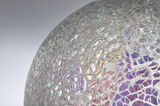 Close-up of a glass mosaic sphere with transparent and purple pieces for decorative lighting.