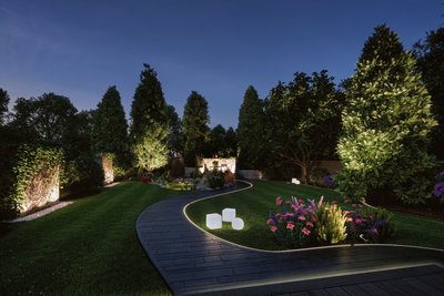 Beleuchteter Gartenweg mit LED-Bodeneinbauleuchten und dekorativen Gartenlampen bei Nacht