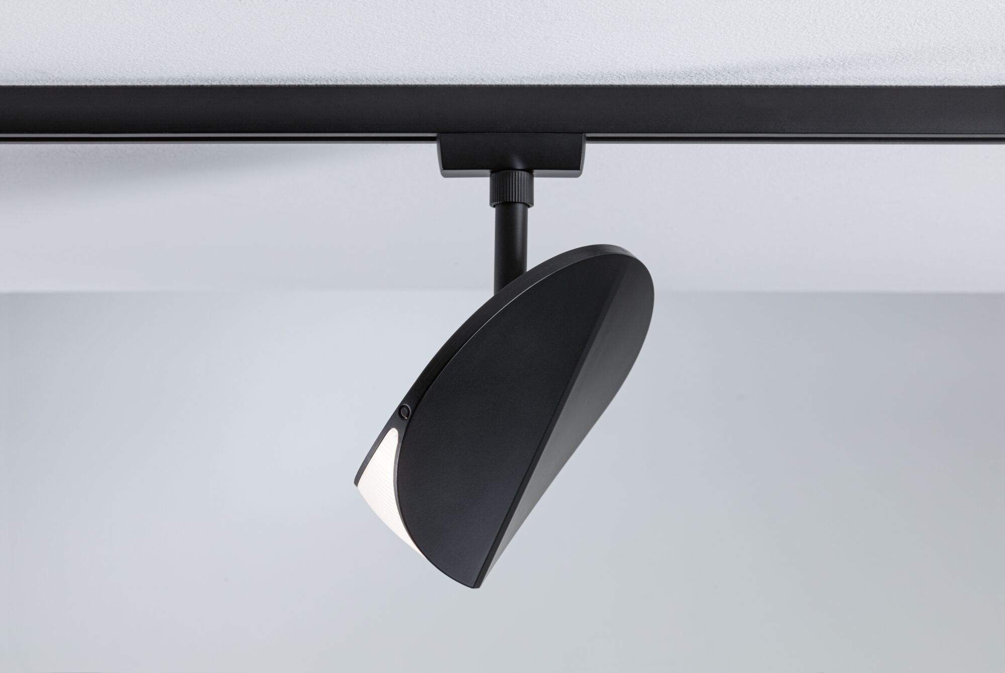 Schwarzer LED-Spot aus Metall an Schienensystem für moderne Innenbeleuchtung