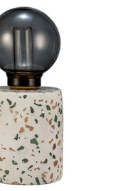 Table lamp with white terrazzo base featuring colored chips and black glass bulb, modern lighting design