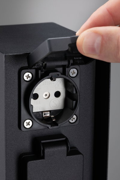 Black plastic socket with protective cover, grounded outlet suitable for outdoor use